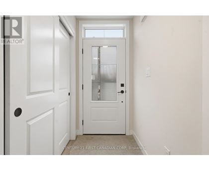 A white door with a window above it in a room.