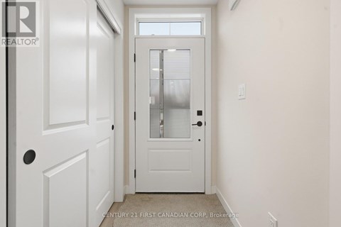 A white door with a window above it in a room.