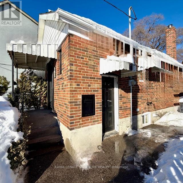 A house with a black door and a brick wall.