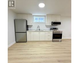 A kitchen with white cabinets and a stainless steel refrigerator.