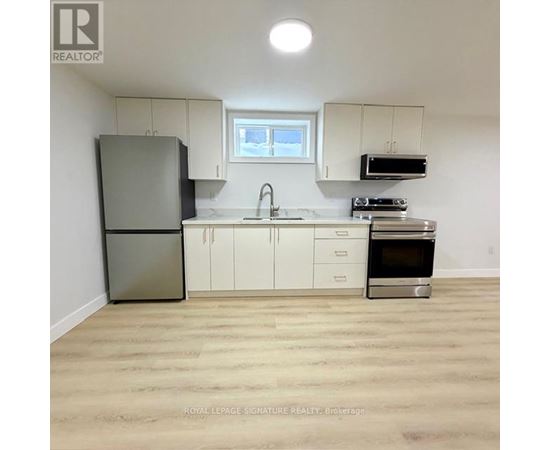 A kitchen with white cabinets and a stainless steel refrigerator.