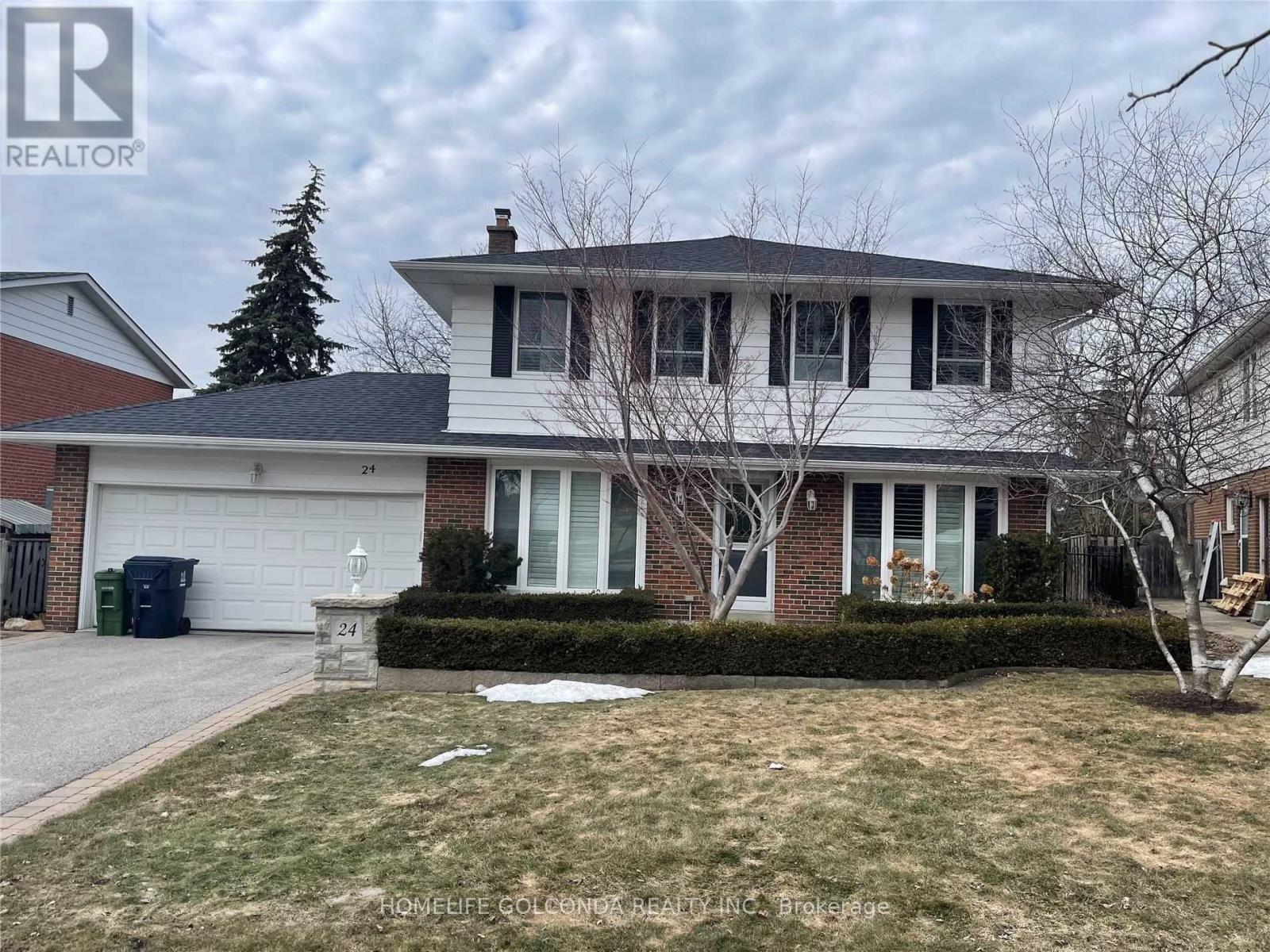 A two-story house with a white garage door and a tree in front.