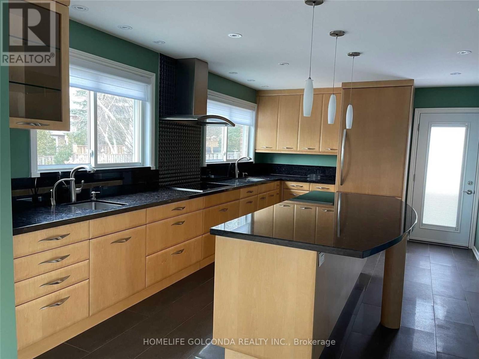 A kitchen with wooden cabinets and a black countertop.