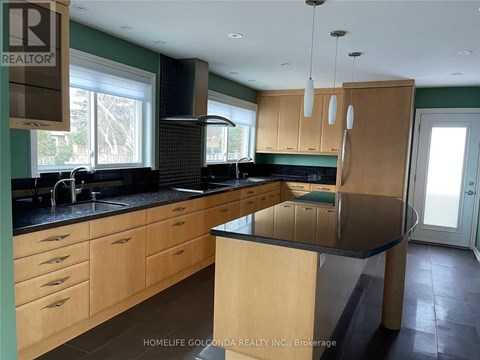 A kitchen with wooden cabinets and a black countertop.