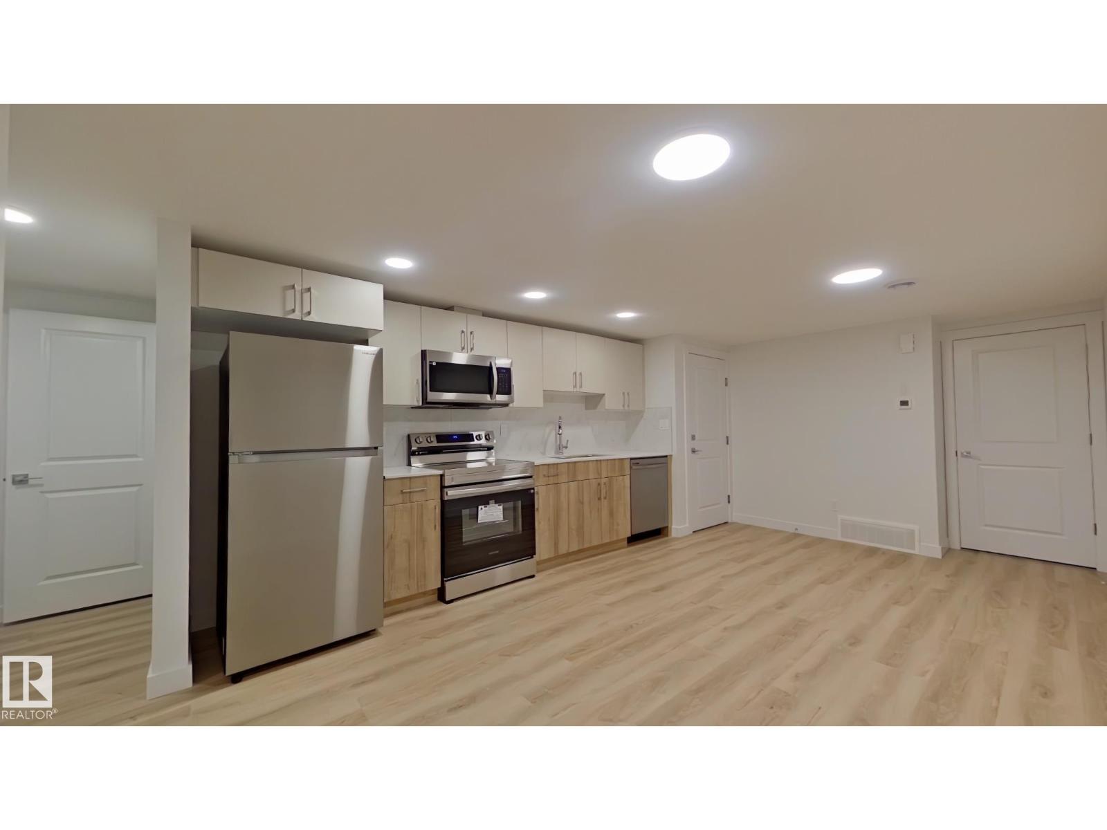 A kitchen with wooden floors and white walls.
