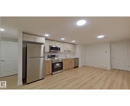 A kitchen with wooden floors and white walls.