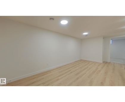 A room with wooden flooring and white walls.