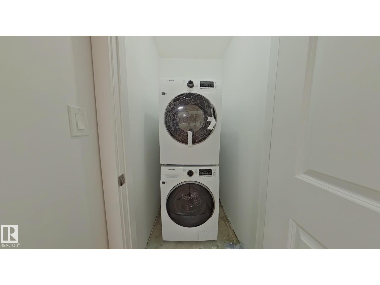 A white washing machine and dryer in a small laundry room.