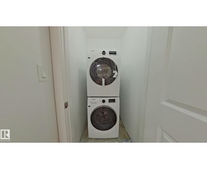 A white washing machine and dryer in a small laundry room.