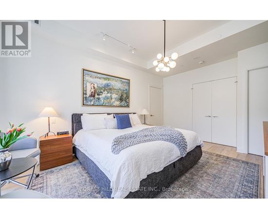 A bedroom with a large bed and a painting on the wall.