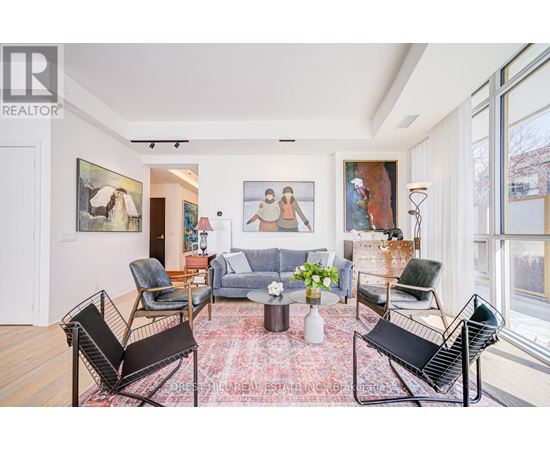 A living room with a rug and a painting on the wall.