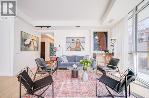 A living room with a rug and a painting on the wall.