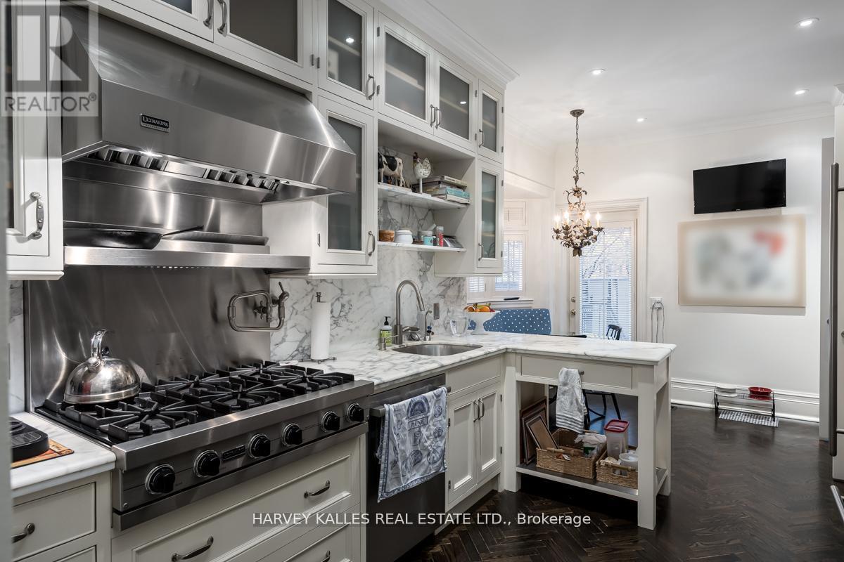 A modern kitchen with a stainless steel stove and white cabinets.