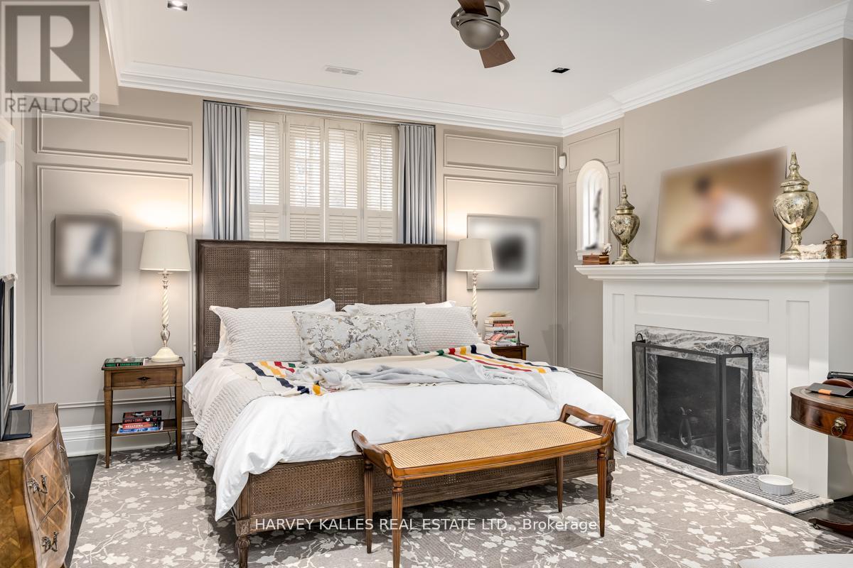 A bedroom with a large bed and a fireplace.