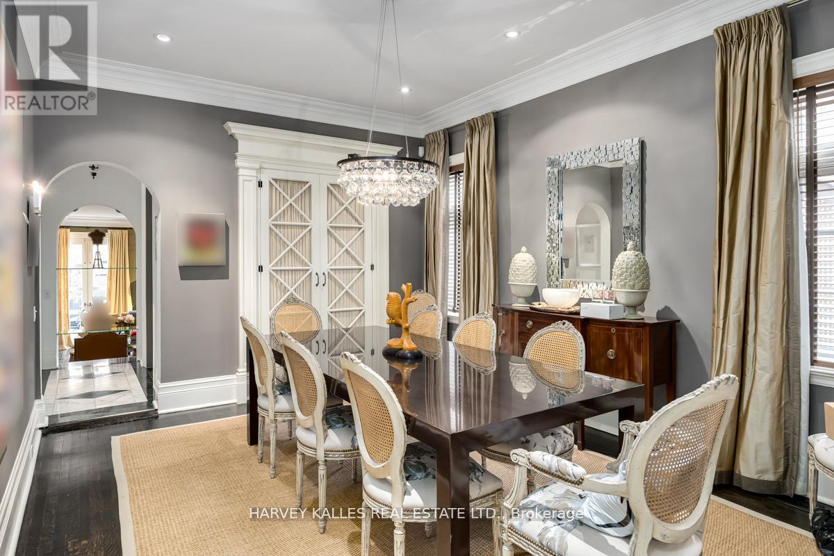 A dining room with a large table and chairs.