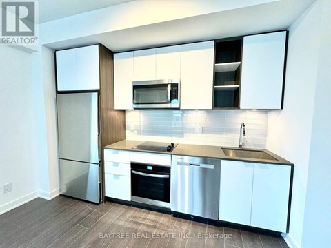 A modern kitchen with white cabinets and stainless steel appliances.