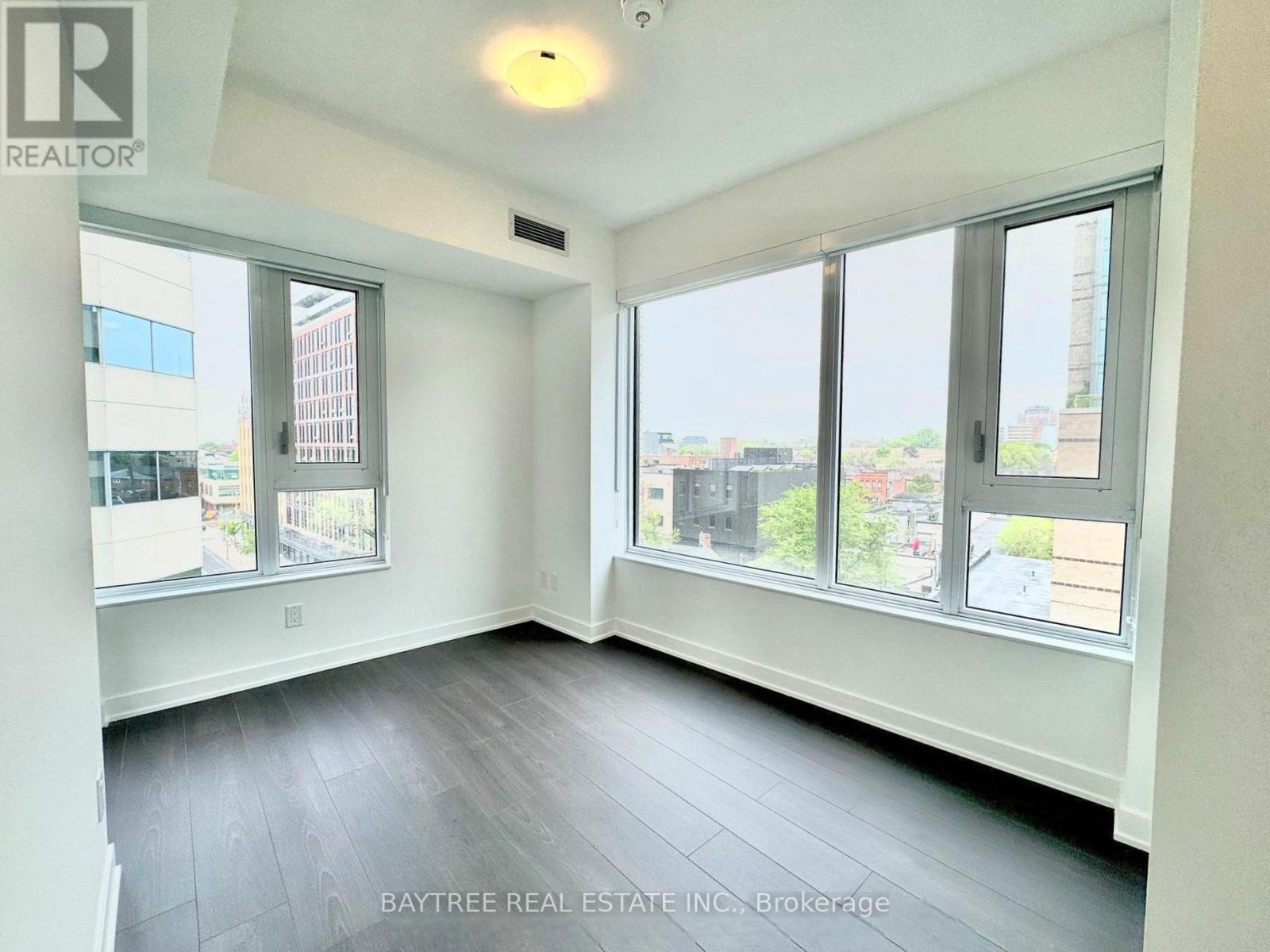 A spacious room with a view of the city through large windows.