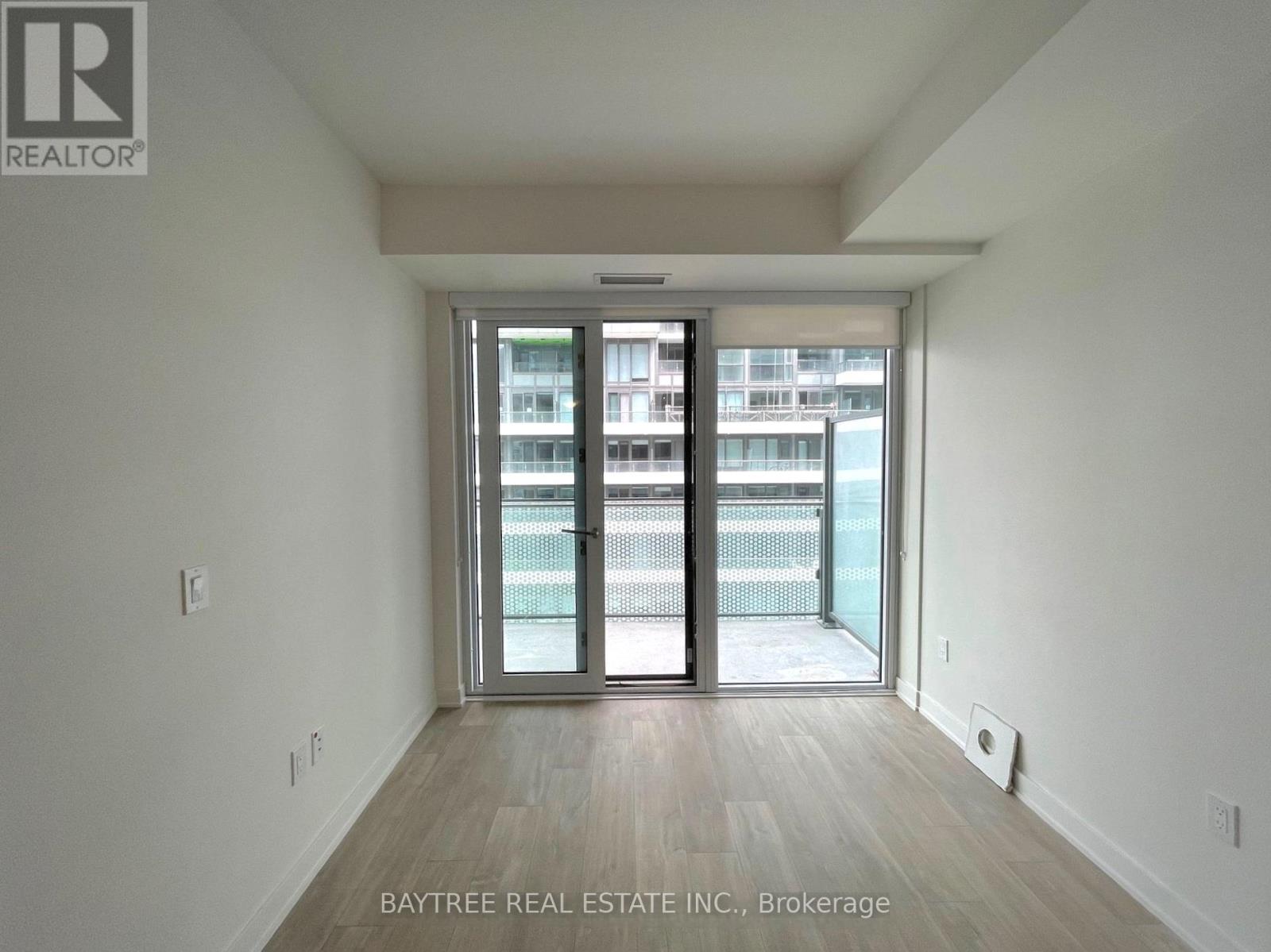 A room with a sliding glass door leading to a balcony.
