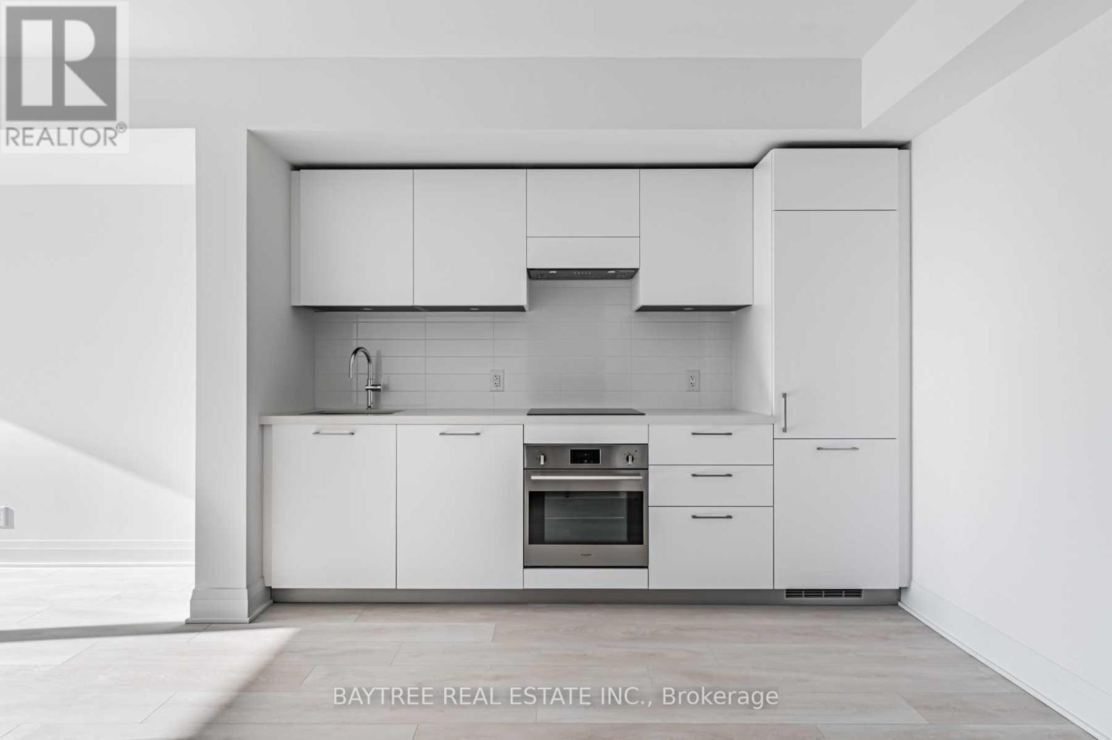 A modern kitchen with white cabinets and appliances.
