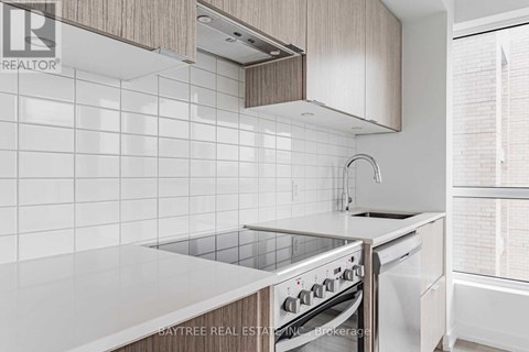 A modern kitchen with a stove top oven and a white counter top.