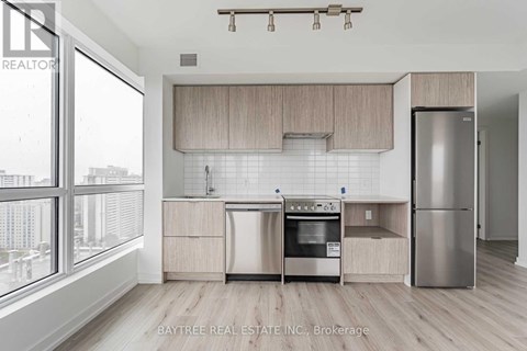 A kitchen with a stainless steel refrigerator and a dishwasher.
