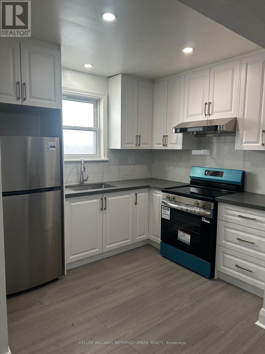A kitchen with white cabinets and a stainless steel refrigerator.