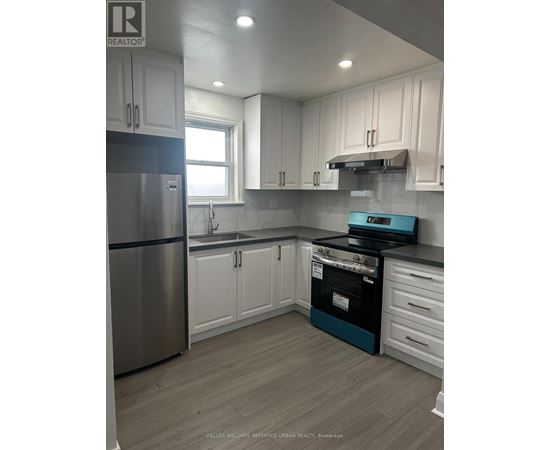 A kitchen with white cabinets and a stainless steel refrigerator.