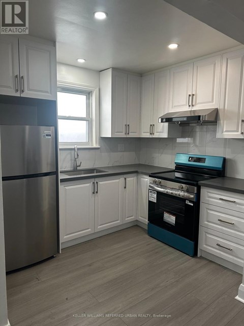 A kitchen with white cabinets and a stainless steel refrigerator.