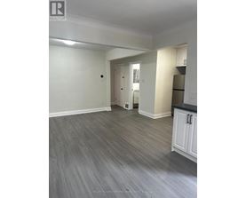 A spacious room with a grey floor and white walls.