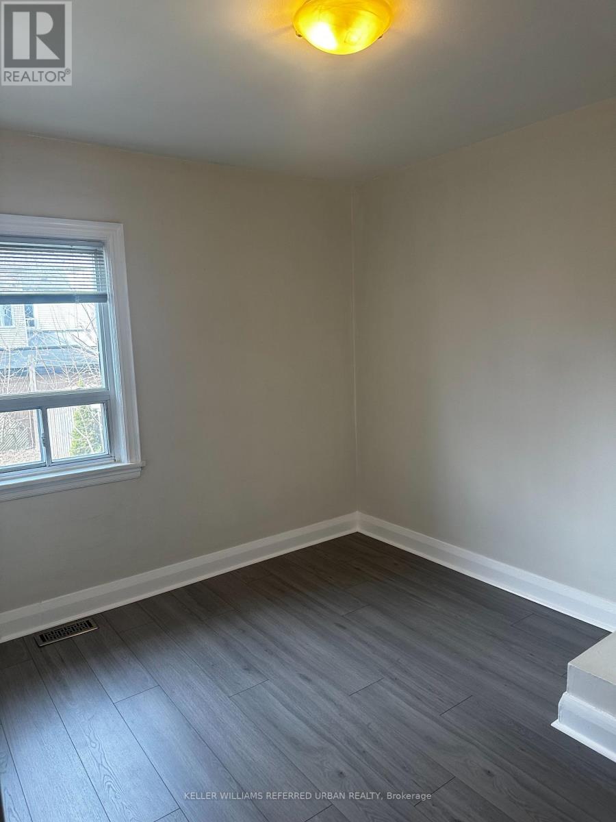 A room with a window and a wooden floor.