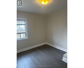A room with a window and a wooden floor.