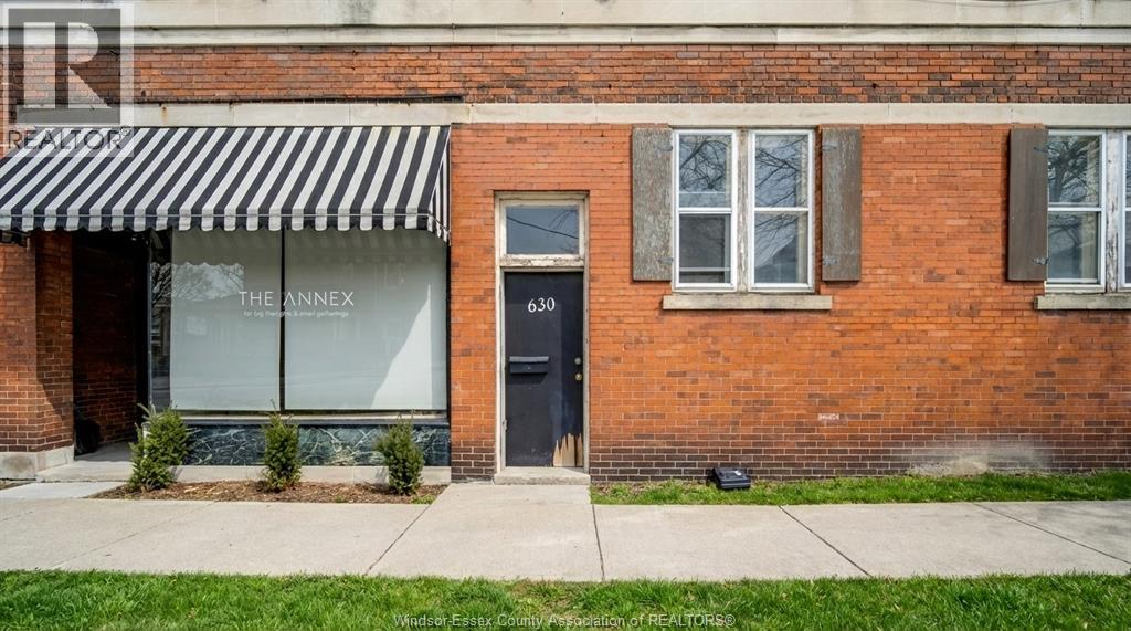 A brick building with a black and white striped awning.