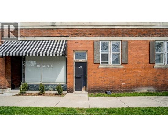 A brick building with a black and white striped awning.