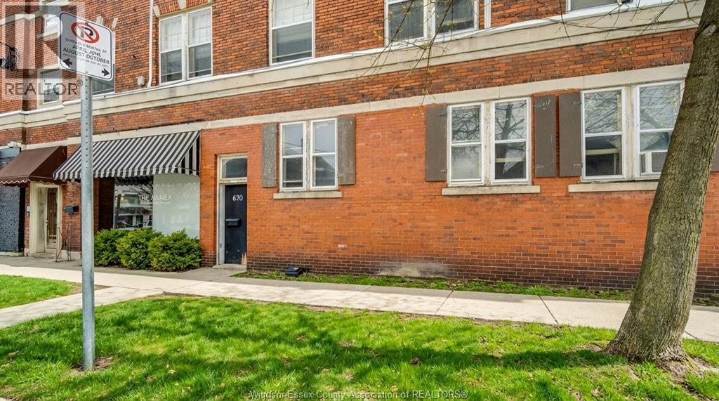 A red brick building with a black awning and a sign that says "REALTOR".