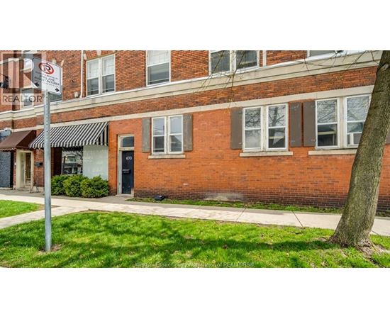 A red brick building with a black awning and a sign that says "REALTOR".