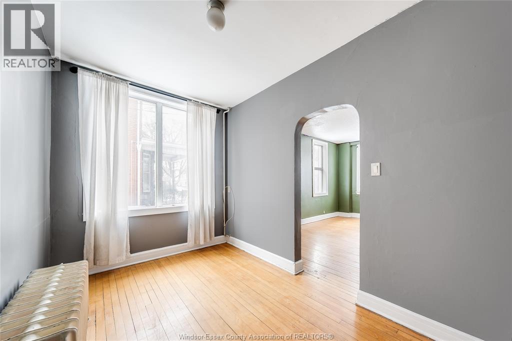 A room with a large window and a wooden floor.