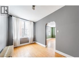 A room with a large window and a wooden floor.
