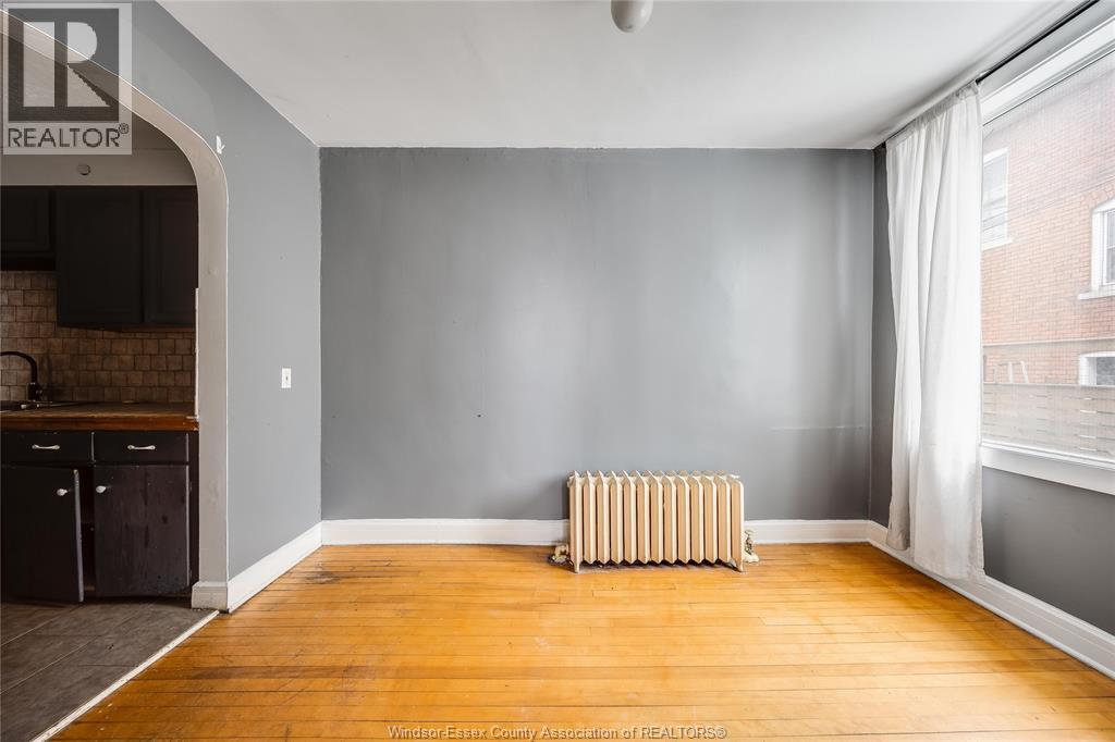 A room with a wooden floor and a radiator.