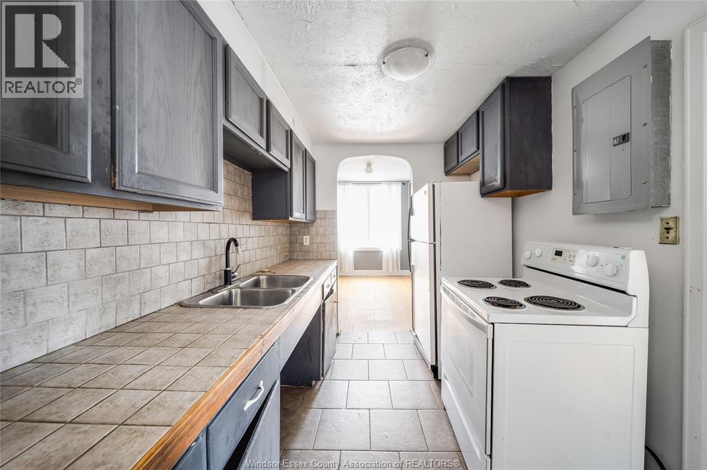 A kitchen with a white stove and a sink.