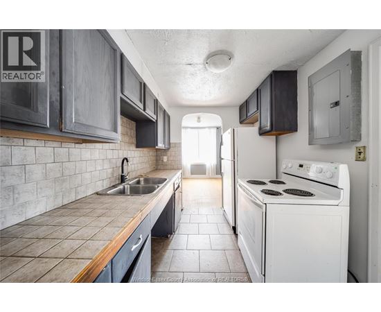 A kitchen with a white stove and a sink.