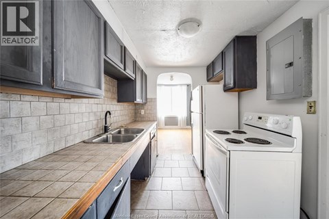 A kitchen with a white stove and a sink.