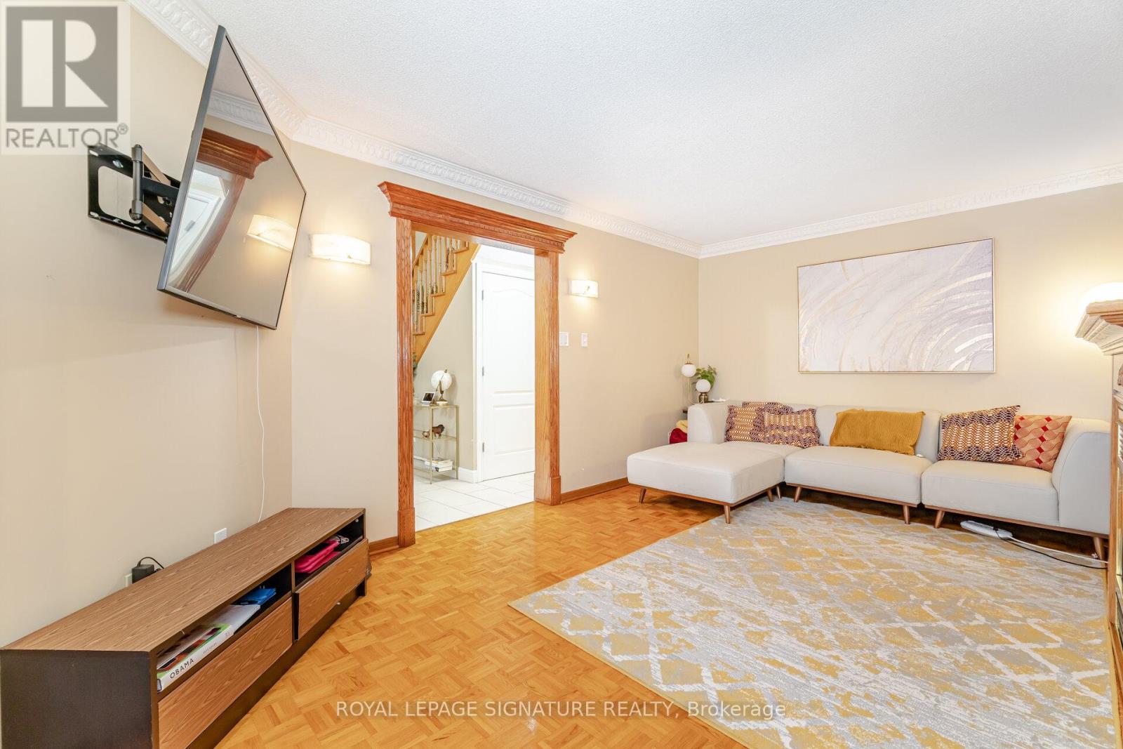 A living room with a white couch and a wooden floor.