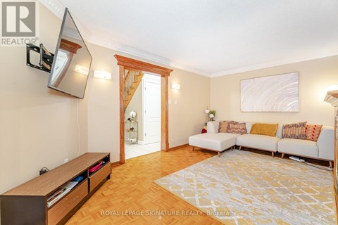 A living room with a white couch and a wooden floor.