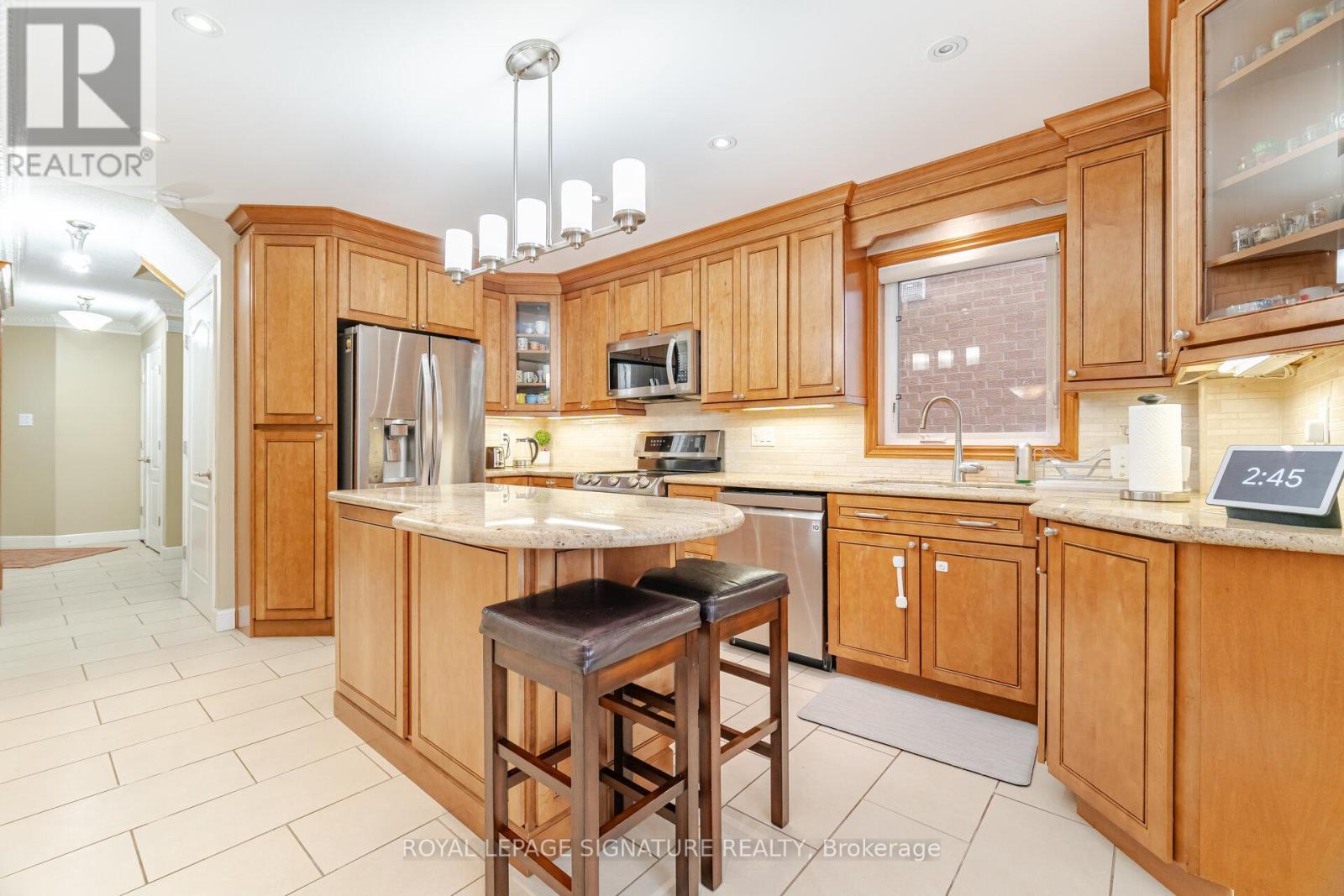 A kitchen with wooden cabinets and a bar stool.
