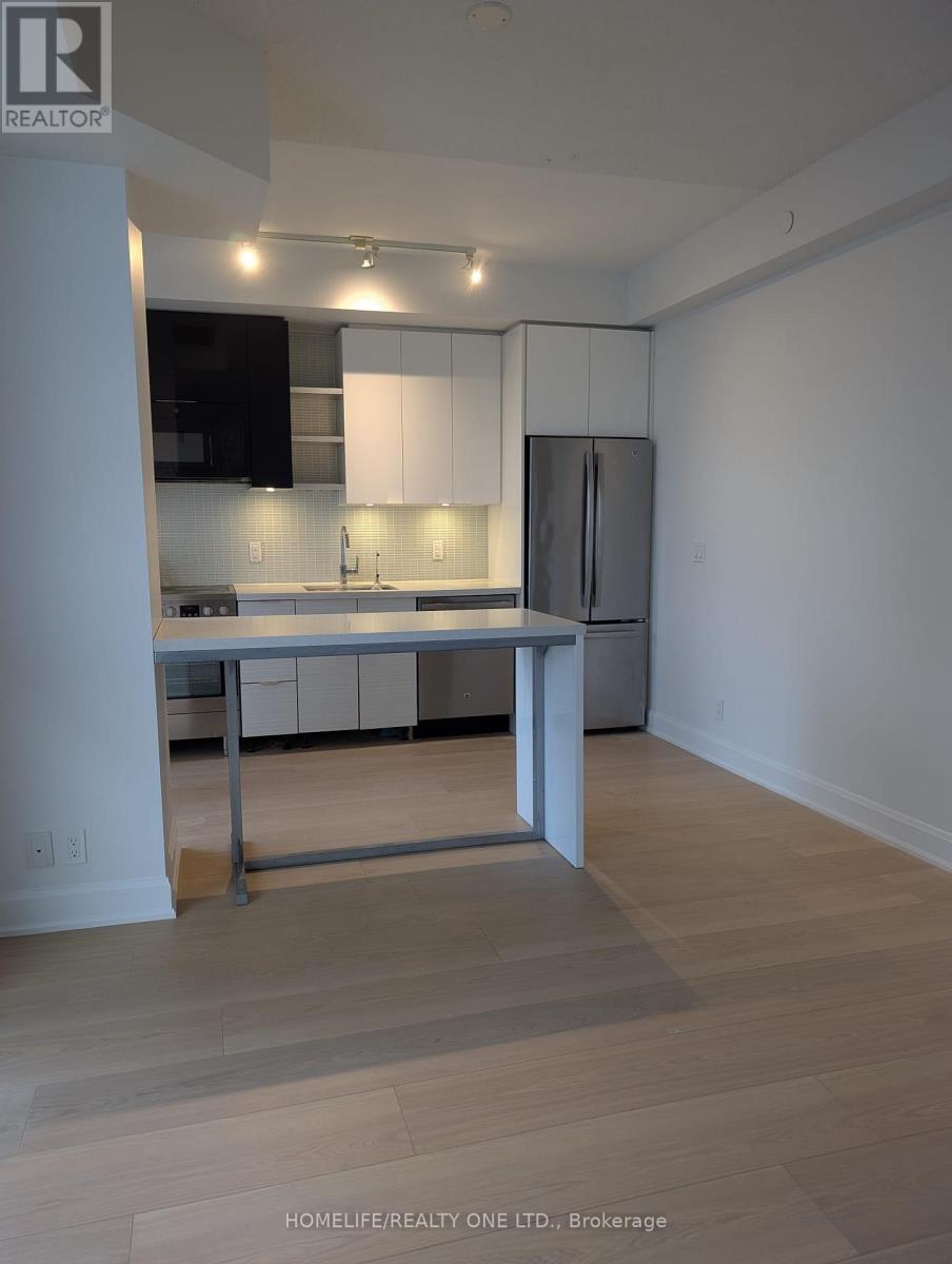 A kitchen with white cabinets and a wooden floor.