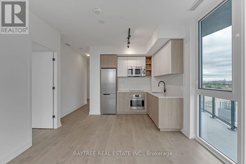 A modern kitchen with wooden floors and white walls.