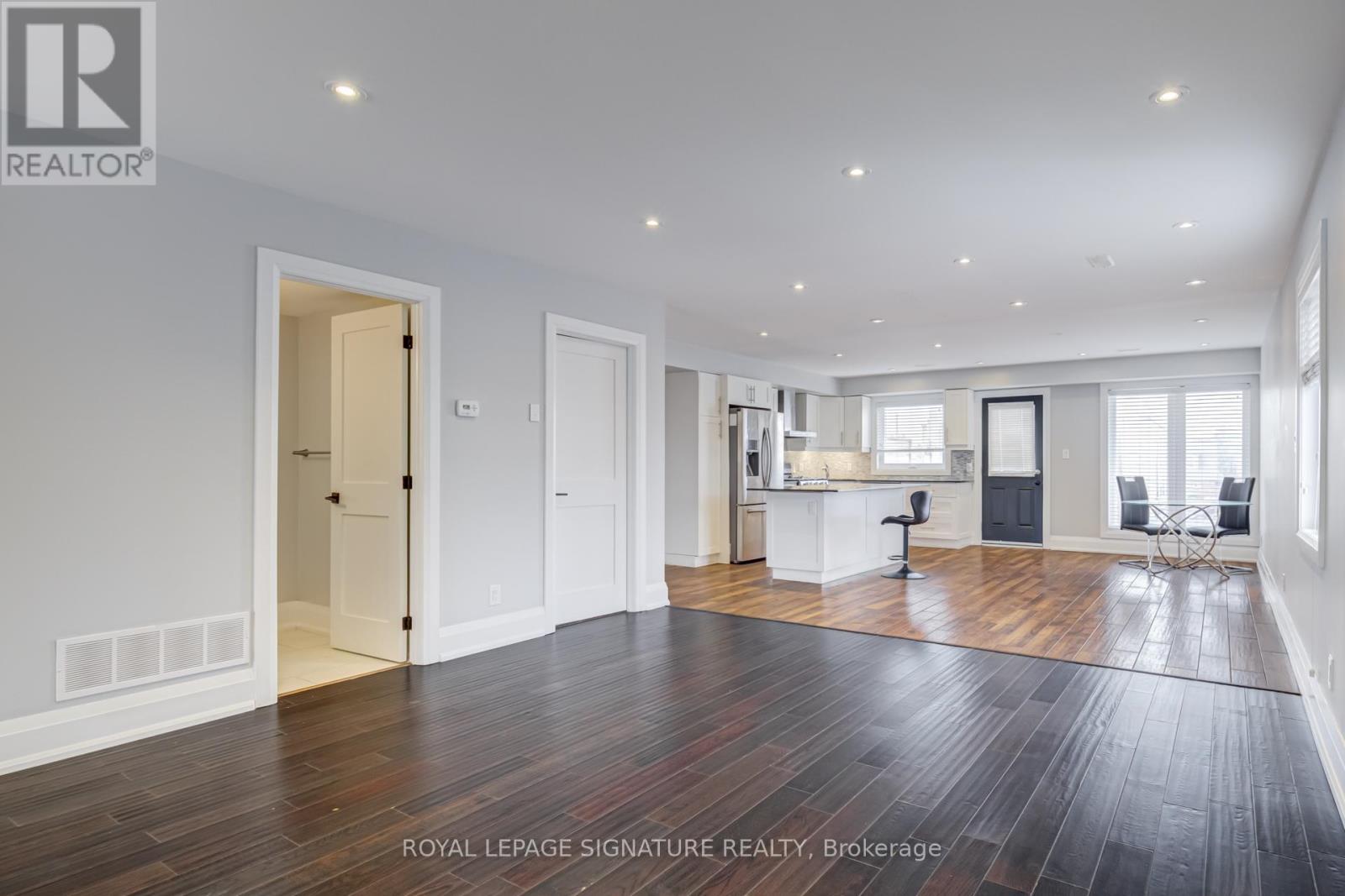 A spacious room with wooden floors and white walls.
