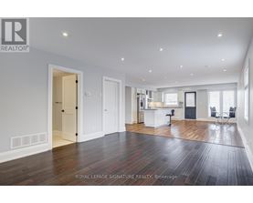 A spacious room with wooden floors and white walls.