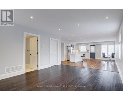 A spacious room with wooden floors and white walls.