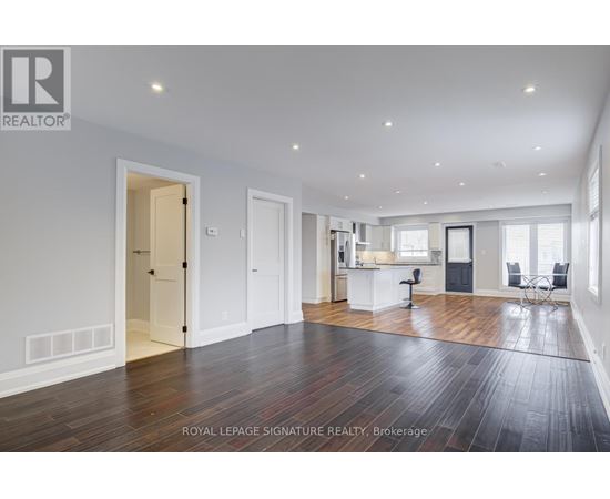 A spacious room with wooden floors and white walls.